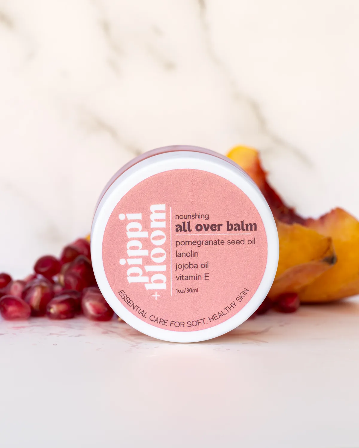 Pippi and Bloom all over balm, lid label-up, with pomegranate seeds and peach slices