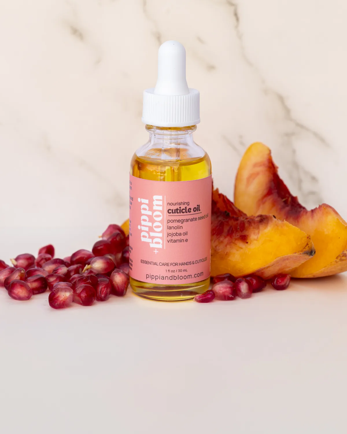 The Pippi and Bloom cuticle oil dropper bottle with pomegranate seeds and peach slices