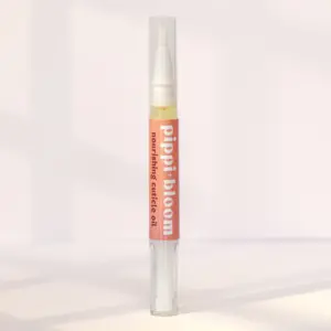 Pippi and Bloom cuticle oil brush pen standing in window light against a pale wall